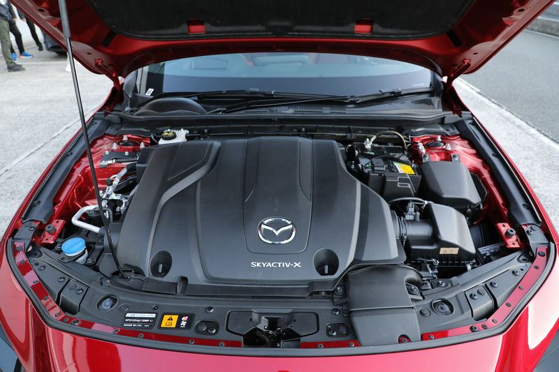 11月に発表された「MAZDA3」商品改良モデル。2021年1月発売予定の新「SKYACTIV-X」搭載モデルでは、エンジンとトランスミッションを制御するソフトウェアをアップデート。SPCCI（火花点火制御圧縮着火）の燃焼制御を最適化することで、最高出力は従来の132kW（180PS）から140kW（190PS）に、最大トルクは従来の224Nmから240Nmにそれぞれ向上（エンジンの写真はプロトタイプのもの）。また、今回新たにリア部には「e-SKYACTIV X」バッヂを装備した