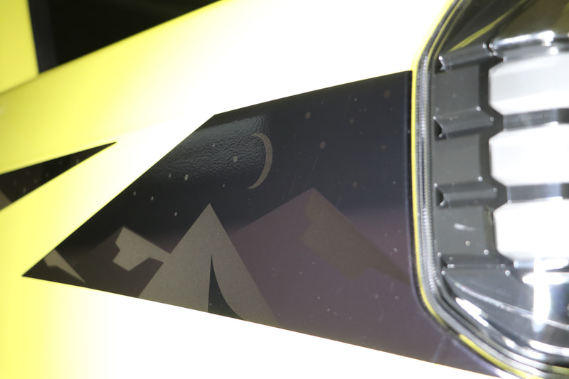 ヘッドライト横の黒いシールからは、月や山脈が浮かび上がる