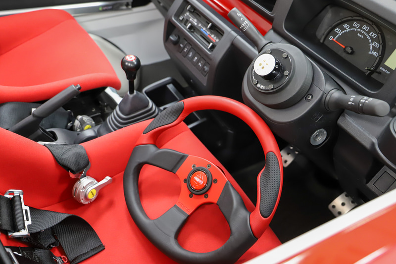 内装は、“還暦祝い”もイメージした赤が映える。屋根がなくなった分の剛性を確保するため、D-SPORTのバーを追加している