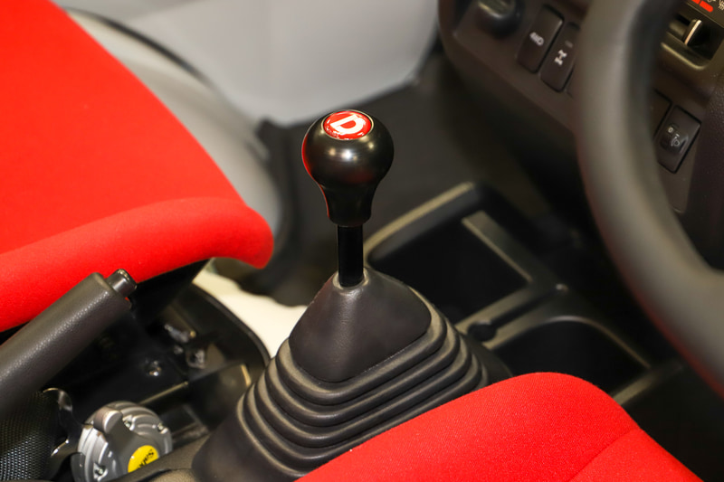 内装は、“還暦祝い”もイメージした赤が映える。屋根がなくなった分の剛性を確保するため、D-SPORTのバーを追加している