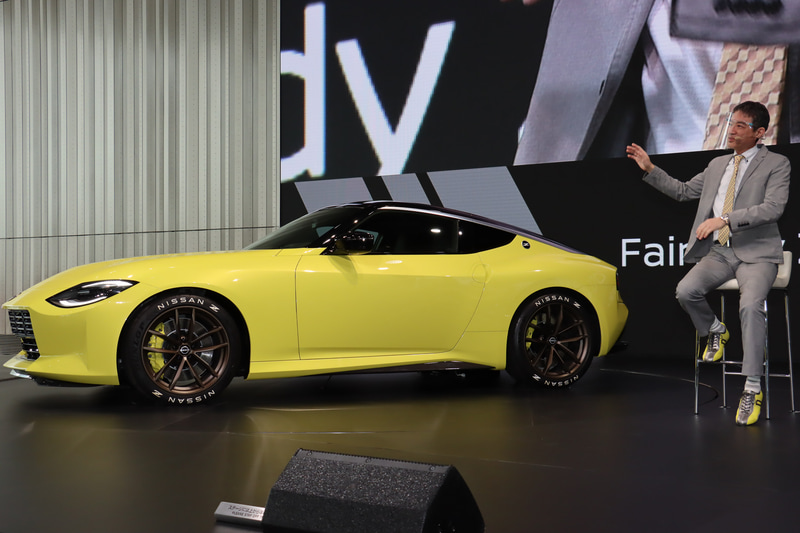 クルマのデザインにおけるリアビューの重要性について自説を語る田村氏。入江氏は「ここにいる人（田村氏）が一番厳しいんです！　デザイナーじゃないのにデザインスタジオにずっといるんですよ」と語り、デザインに対する田村氏のこだわりをアピールした