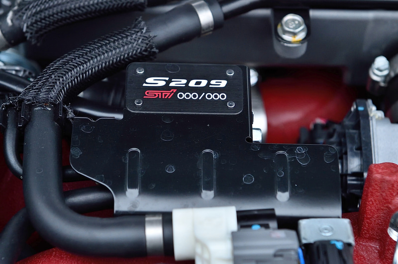 北米向けなので左ハンドル仕様。ダッシュボードやシートベルトなど各所にSTIカラーのチェリーレッドが配され、運転席と助手席は専用シートを装着。エクステリアもフロントグリル、フロントフェンダー、トランクゲートにS209のエンブレムが配される