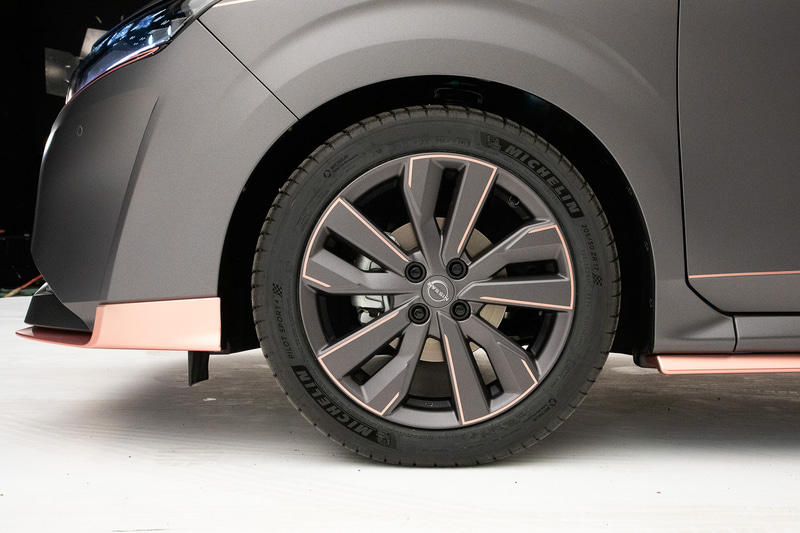 欧州向けに生産されているマイクラ用の17インチホイールを装着。ホイールカラーもボディに合わせていて、4mm幅のピンクゴールドストライプ入り。こちらのストライブはホイールを大きく見せることを意識したデザインにしているとのこと。タイヤもインチアップしているが、外径は純正タイヤとほぼ同じとのこと