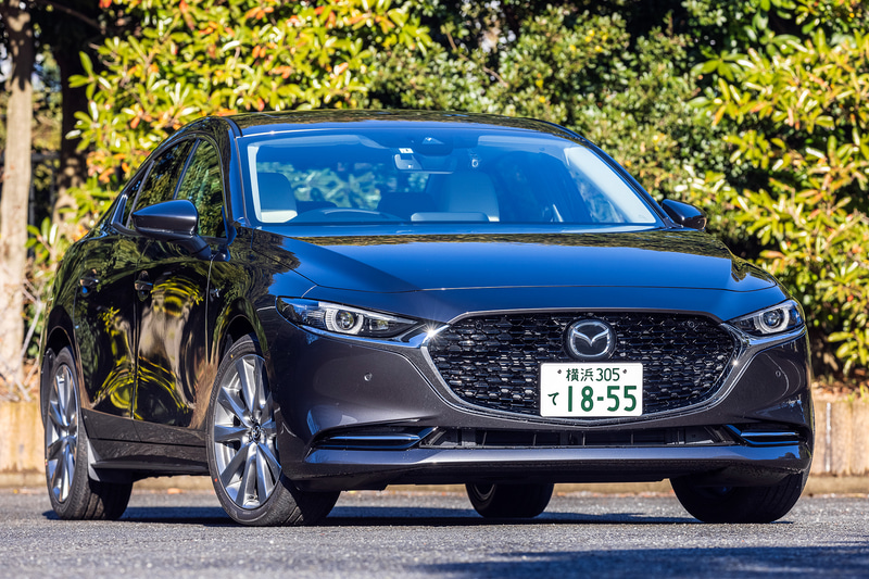 今回試乗したのは2020年11月に商品改良した「MAZDA3」。写真はセダンの「X L Package」（2WD/338万463円）で、ボディサイズは4660×1795×1445mm（全長×全幅×全高）、ホイールベースは2725mm。今回の改良で外観ではフロントフェンダー部に「SKYACTIV-X」バッヂを、リア部に「e-SKYACTIV X」バッヂを装備。足下は18インチホイールにブリヂストン「TURANZA T005A」（215/45R18）を組み合わせる