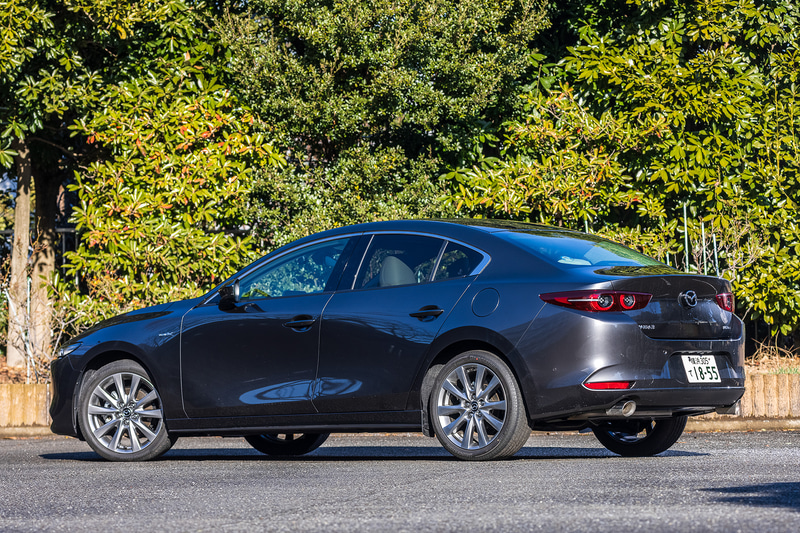 今回試乗したのは2020年11月に商品改良した「MAZDA3」。写真はセダンの「X L Package」（2WD/338万463円）で、ボディサイズは4660×1795×1445mm（全長×全幅×全高）、ホイールベースは2725mm。今回の改良で外観ではフロントフェンダー部に「SKYACTIV-X」バッヂを、リア部に「e-SKYACTIV X」バッヂを装備。足下は18インチホイールにブリヂストン「TURANZA T005A」（215/45R18）を組み合わせる