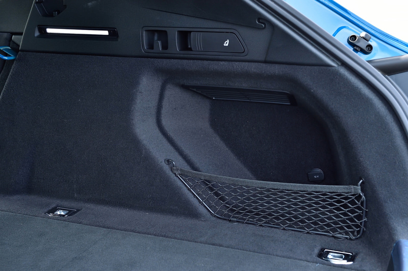 ラゲッジスペース両サイドにはネット付きの小物入れ。上にはリアシートを倒すレバーを配置