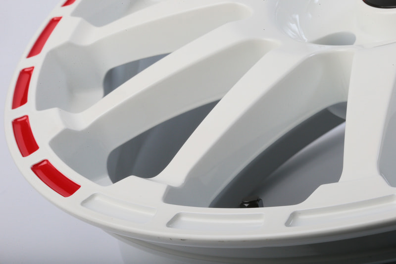 角となる5つディンプル群に赤い差し色が入る。あえて一部のみ色を入れることでホイールデザインに動きを与えている