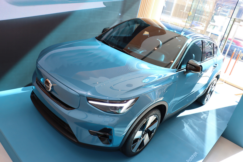 展示車の背後にあるディスプレイでセンターコンソールのインフォテインメントシステムについて紹介