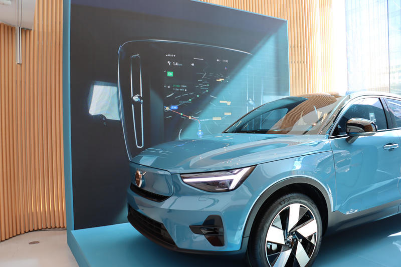 展示車の背後にあるディスプレイでセンターコンソールのインフォテインメントシステムについて紹介