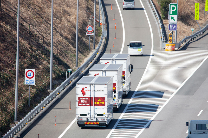 実証走行では3台の大型トラックが約9mの車間距離を維持しながら80km/hで走行。動画では周囲の安全にもしっかりと配慮しつつ、スムーズに走行する姿を紹介している