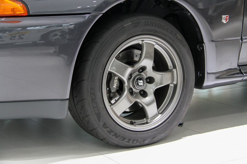 NISMOによって生まれ変わったR32 スカイラインGT-R。1つひとつの部品の輝きもさることながら、ドアノブを引いた際やドアを閉めた音からも「ああ、新車のときってこんな感じだったのね」ということが実感できる。劣化すると見た目で古さを感じさせるウィンドウモール類も新しい。新車装着されていたタイヤはブリヂストンの「ポテンザ RE71」だが、レストア車では「ポテンザ RE-71R」をチョイス