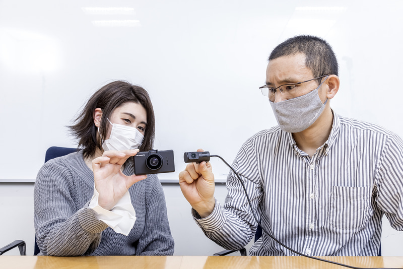 VREC-DH300Dを手に取るCar Watch編集部の北村氏（左）