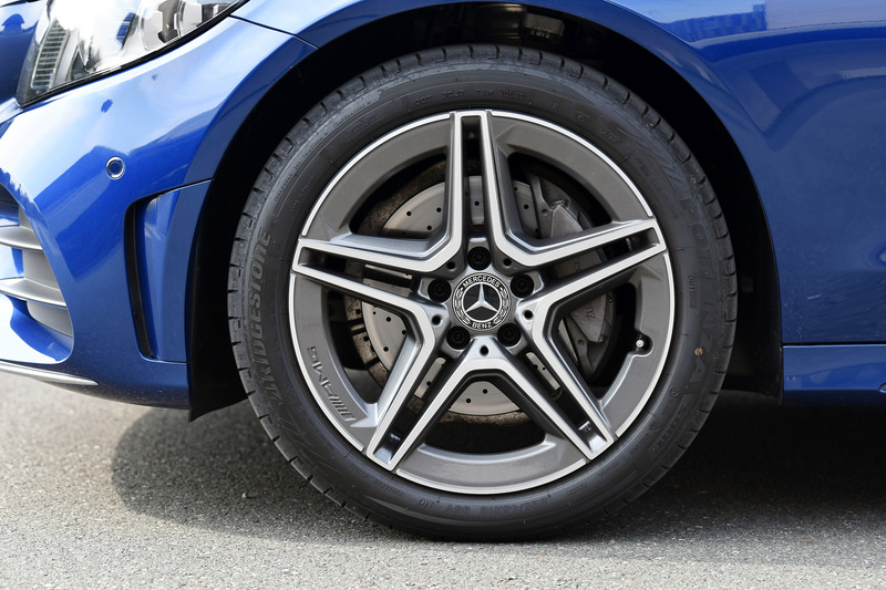 マルチビームLEDヘッドライトや18インチAMGアルミホイール＆ブリヂストン「ポテンザ S001」などを装着。その奥にはMercedes-Benzロゴ付ブレーキキャリパーやドリルドベンチレーテッドディスク（フロント）が見える