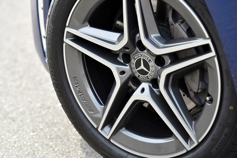 マルチビームLEDヘッドライトや18インチAMGアルミホイール＆ブリヂストン「ポテンザ S001」などを装着。その奥にはMercedes-Benzロゴ付ブレーキキャリパーやドリルドベンチレーテッドディスク（フロント）が見える