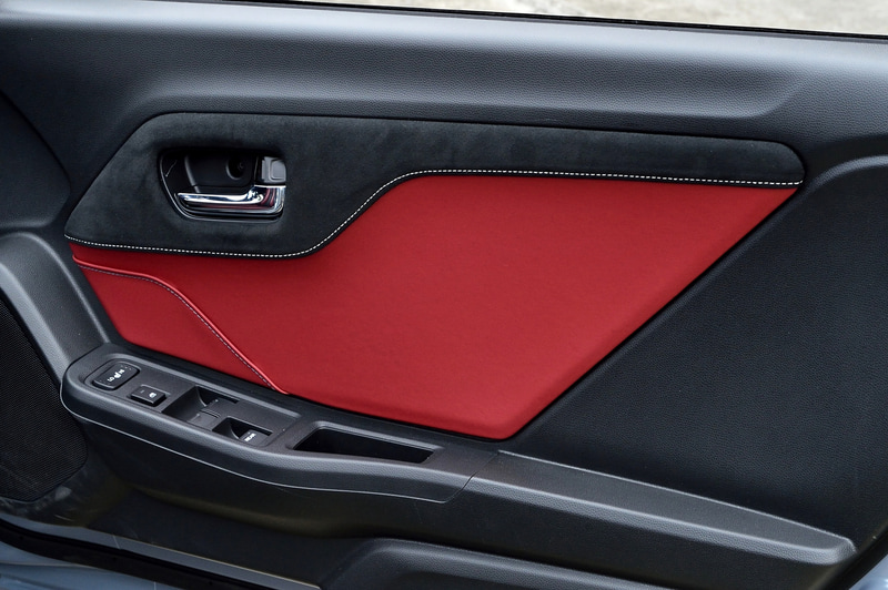 ドアライニングパネルもブラックのラックス スェード×ボルドーレッドの合皮製×グレーステッチを採用。カードなどを収納できるスリットも付いている