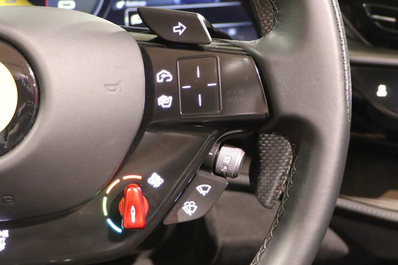 パドルシフト付きのカーボン製ステアリング、ボタン類は突起のない静電式となっている