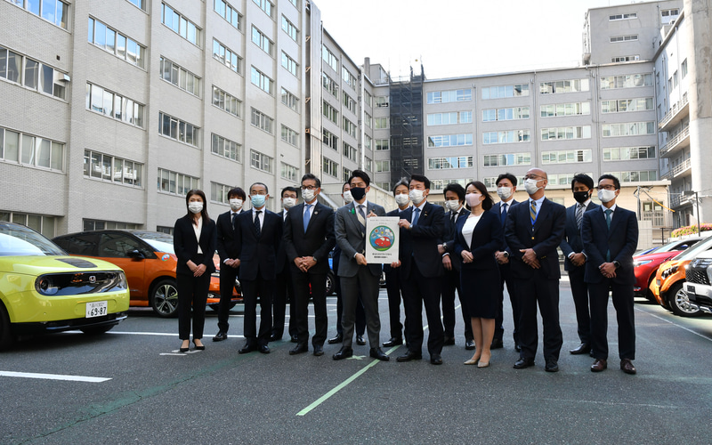 環境省に集まった環境対応車を販売する13社とともに記念写真