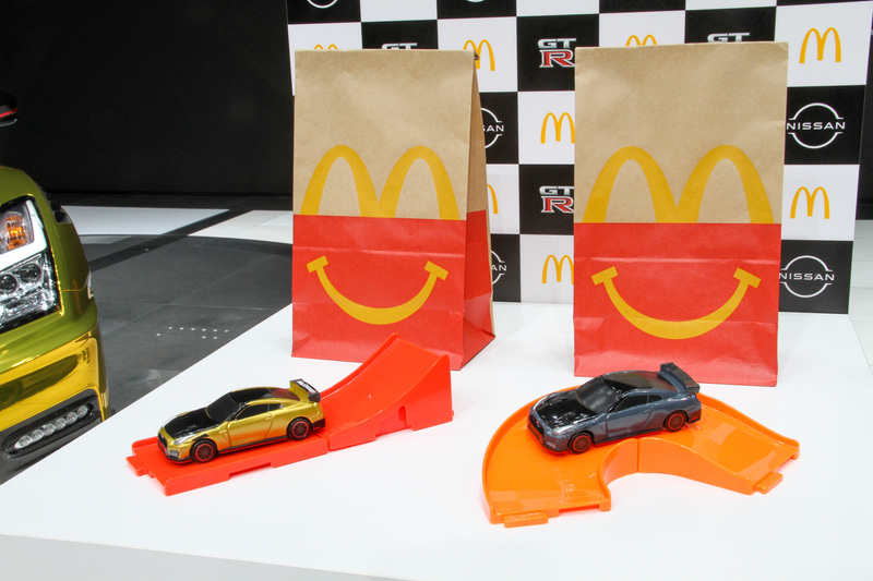 ハッピーセットで用意されるひみつのおもちゃの「日産 GT-R NISMO 2022年モデル マクドナルド仕様“ゴールド”、通常のおもちゃとなるNISMOステルスグレーを模した「日産 GT-R NISMO 2022年モデル」