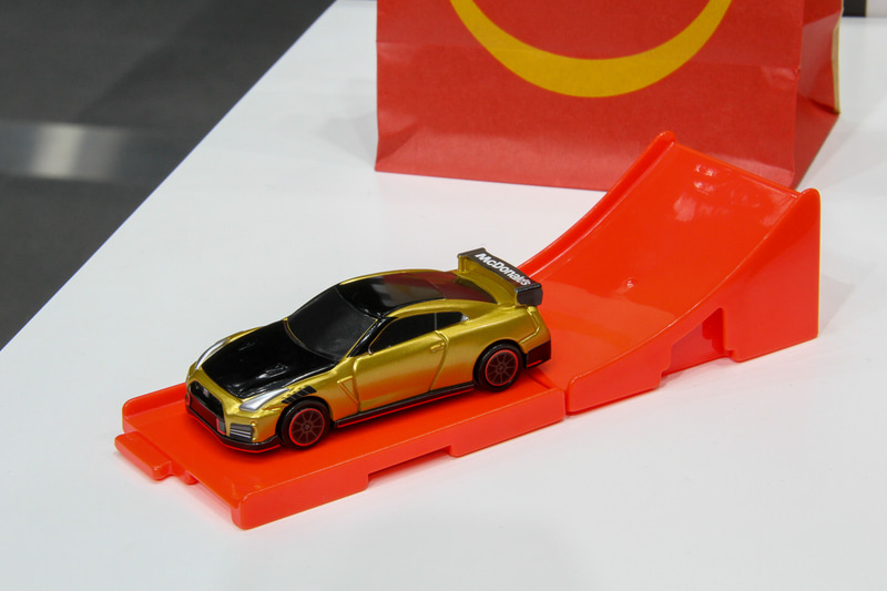 ハッピーセットで用意されるひみつのおもちゃの「日産 GT-R NISMO 2022年モデル マクドナルド仕様“ゴールド”、通常のおもちゃとなるNISMOステルスグレーを模した「日産 GT-R NISMO 2022年モデル」