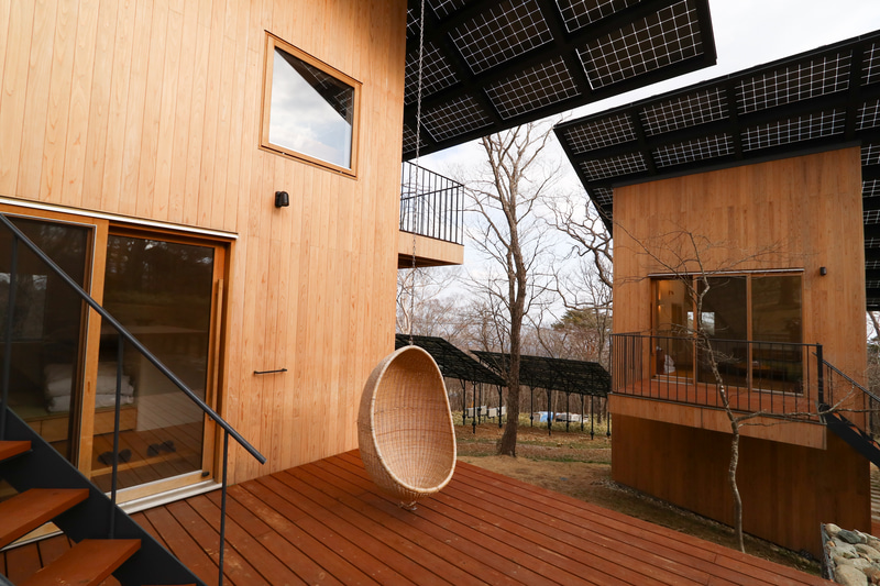 Looop Resort NASUの宿泊する個室棟は2棟あり、どちらも2階建てで上には太陽光パネルが載る。軒下が大きく、テラスも日陰になって過ごしやすい