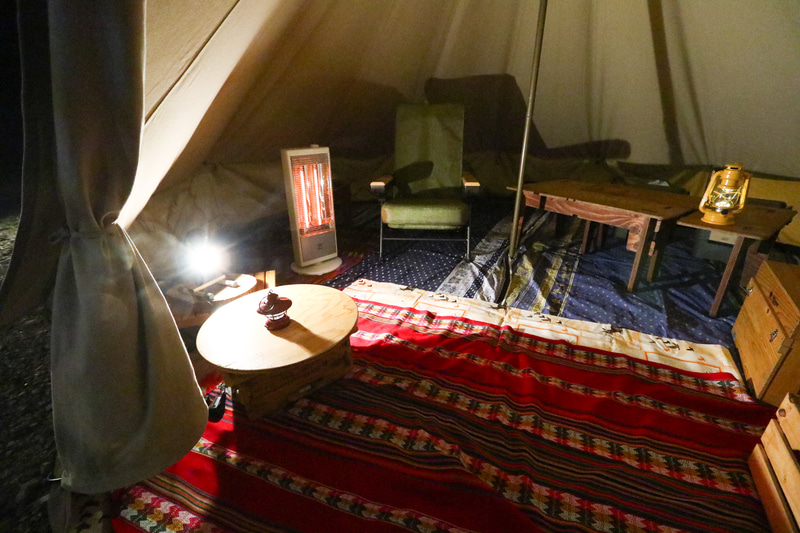 テント内の様子。1000Wの電気ストーブと電気マッサージチェアがあるほか、電気毛布なども用意している