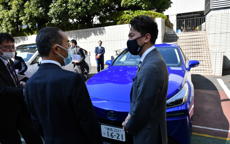 記念写真撮影後、各社担当者と電動化車両について会話する小泉大臣
