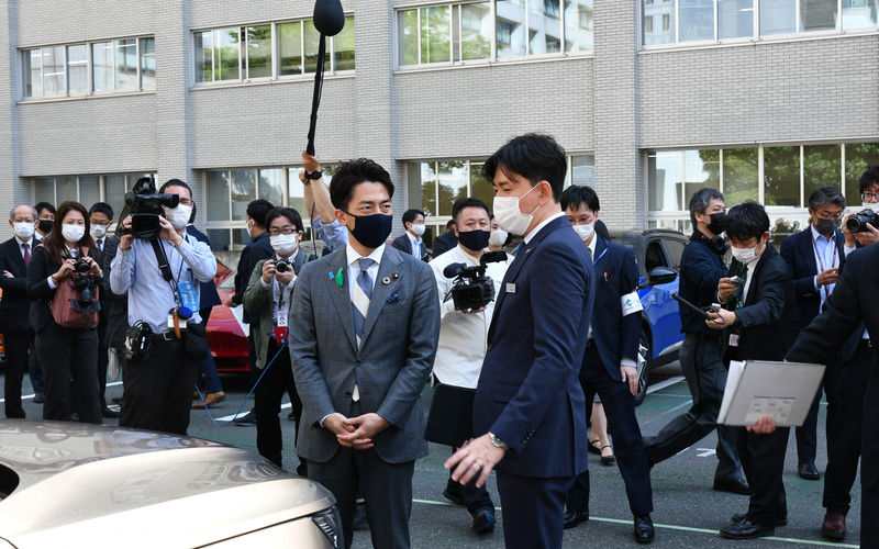 記念写真撮影後、各社担当者と電動化車両について会話する小泉大臣