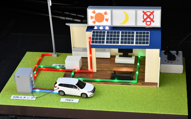 三菱自動車は「エクリプス クロスPHEV」を展示し、ラゲッジルームにV2Hの模型を作り込んでいた