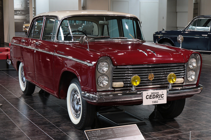 1960年発売、日産・セドリック（30型）。1488cc、水冷4気筒OHVエンジン搭載。縦4灯ヘッドライト、サイドにまわり込んだフロントガラスが特徴（トヨタ博物館展示車）