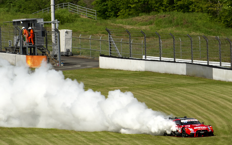 2コーナーの先に煙を噴いてとまる23号車 MOTUL AUTECH GT-R。止まった段階では火も出ていた