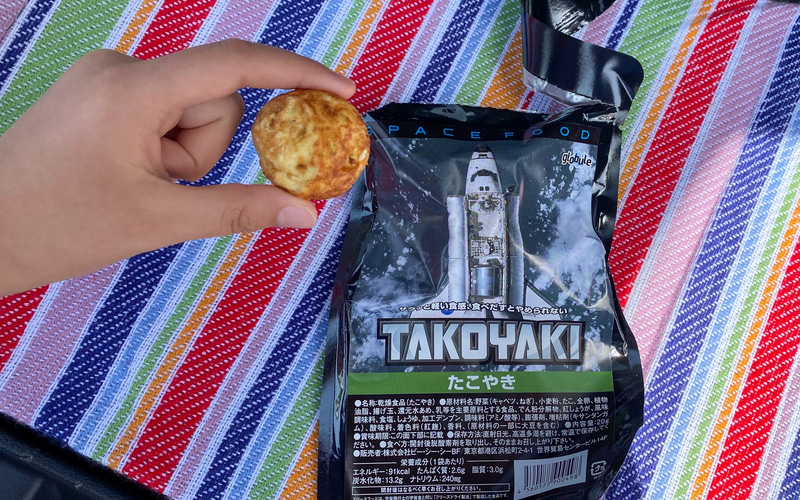宇宙食のたこ焼きって、いったいどんな味？　と興味津々で開けてみたら、パッと見はたこ焼きそのまんま。でも手で持ってみるとカッチカチで中はスッカスカで、本物とのギャップはかなりのものです。でも風味はしっかりたこ焼きっぽかったです