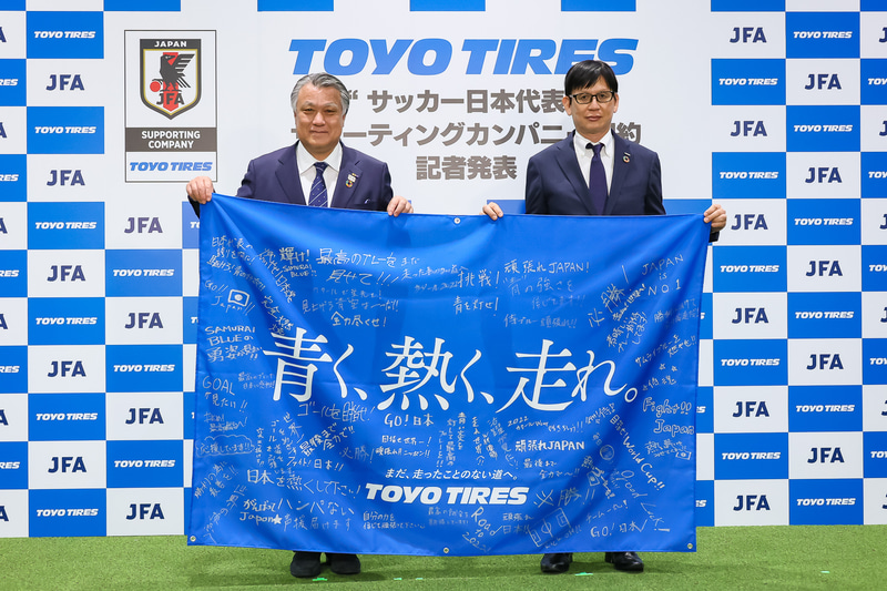 TOYO TIREからJFAに大型フラッグが、JFAからTOYO TIREにサッカー日本代表のユニフォームが贈られた