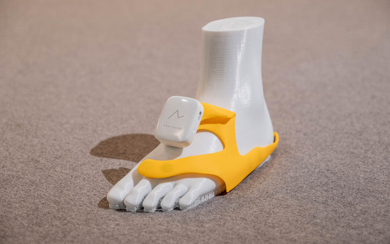 「あしらせ」の立体型のモーションセンサー付き振動デバイスを靴に取り付け、スマートフォンアプリを連動させてナビゲーションを行なう仕組み。振動デバイスを装着したまま、靴の脱ぎ履きもできる