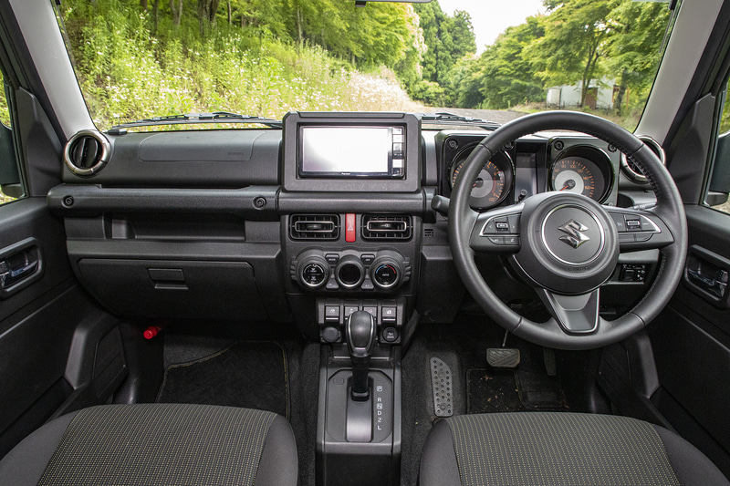 インパネまわりは軽自動車のジムニーと同じくシンプルな作り。ドアにスイッチ類はなく、ミラー系スイッチはインパネ右下、パワーウィンドウ系スイッチはセンターコンソールに付いている。ステアリングにはオーディオとメーター内のインフォメーションを切り替えるスイッチがある