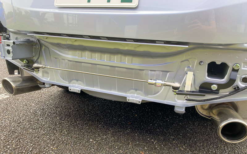 フレキシブルドロースティフナーリヤは左右のリアフレームの後端部（リアバンパーの内部）に装着し、適度なテンションをかけることで走行中のシャシーのしなりを補正し、機敏な初期操舵としなやかな乗り心地を両立するというもの。価格は3万5200円