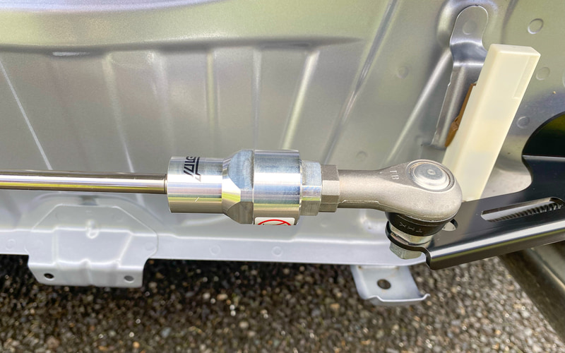 フレキシブルドロースティフナーリヤは左右のリアフレームの後端部（リアバンパーの内部）に装着し、適度なテンションをかけることで走行中のシャシーのしなりを補正し、機敏な初期操舵としなやかな乗り心地を両立するというもの。価格は3万5200円