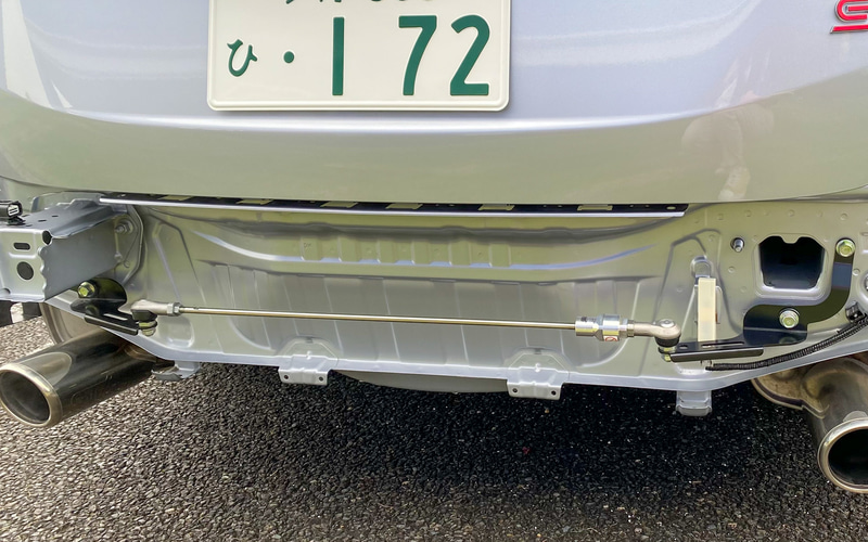 リアバンパーを外すとお目見えするのが、新発売となった「STIフレキシブルドロースティフナー リヤ」。必要な部位に、必要に応じて「引っ張り」のプリロードをかけることで、状況に適した剛性が得られるというものなんです。単品では3万5200円。工賃を含めると、おおよそ4万3000円とのこと。STIフレキシブルタワーバー、STIフレキシブルドロースティフナーと合わせて、ぜひ違いを体感してみてほしいです
