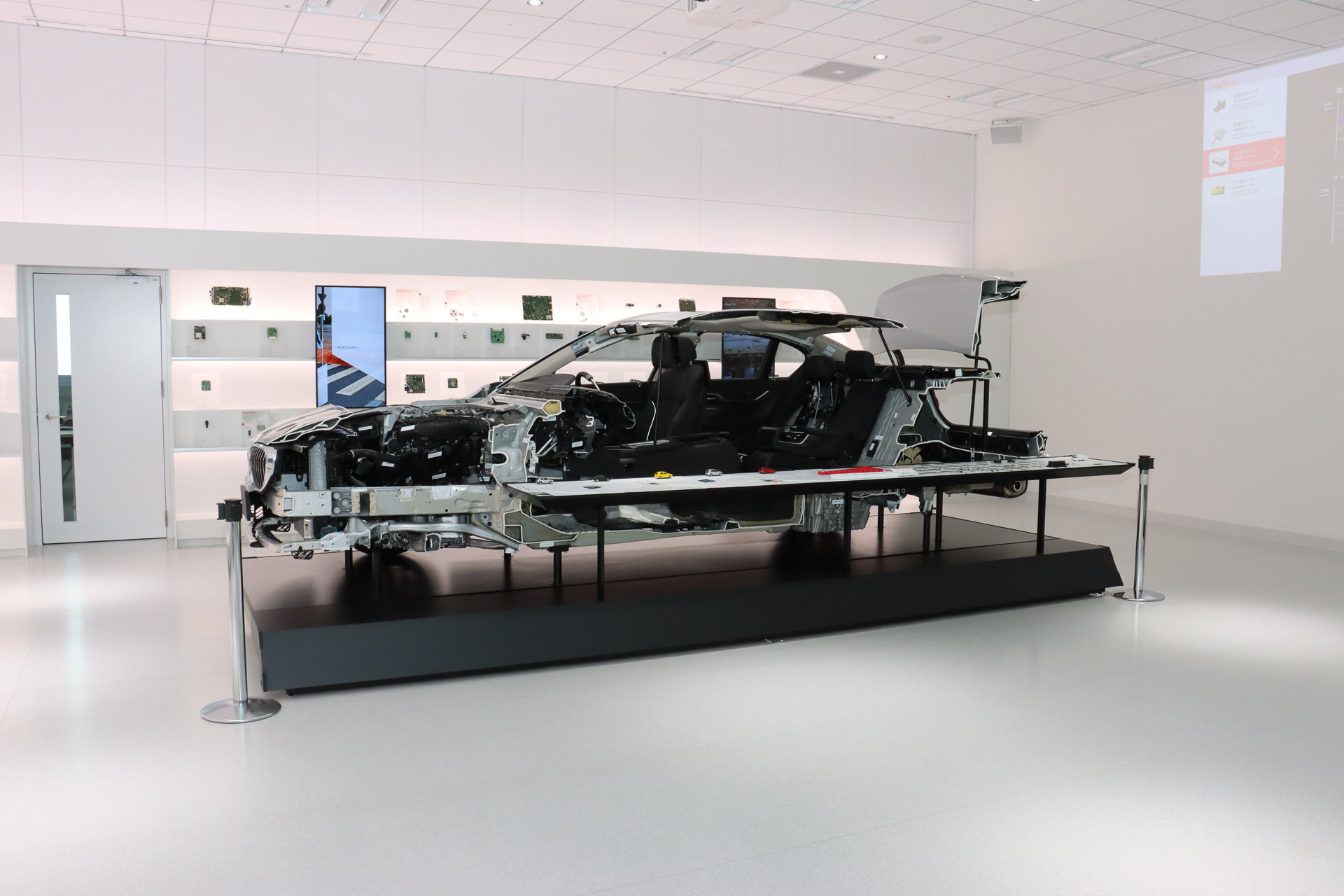 スペース中央に車両のカットモデルをシンボリックに置くことで、同社が自動車市場に本気で取り組んでいる姿勢を表現