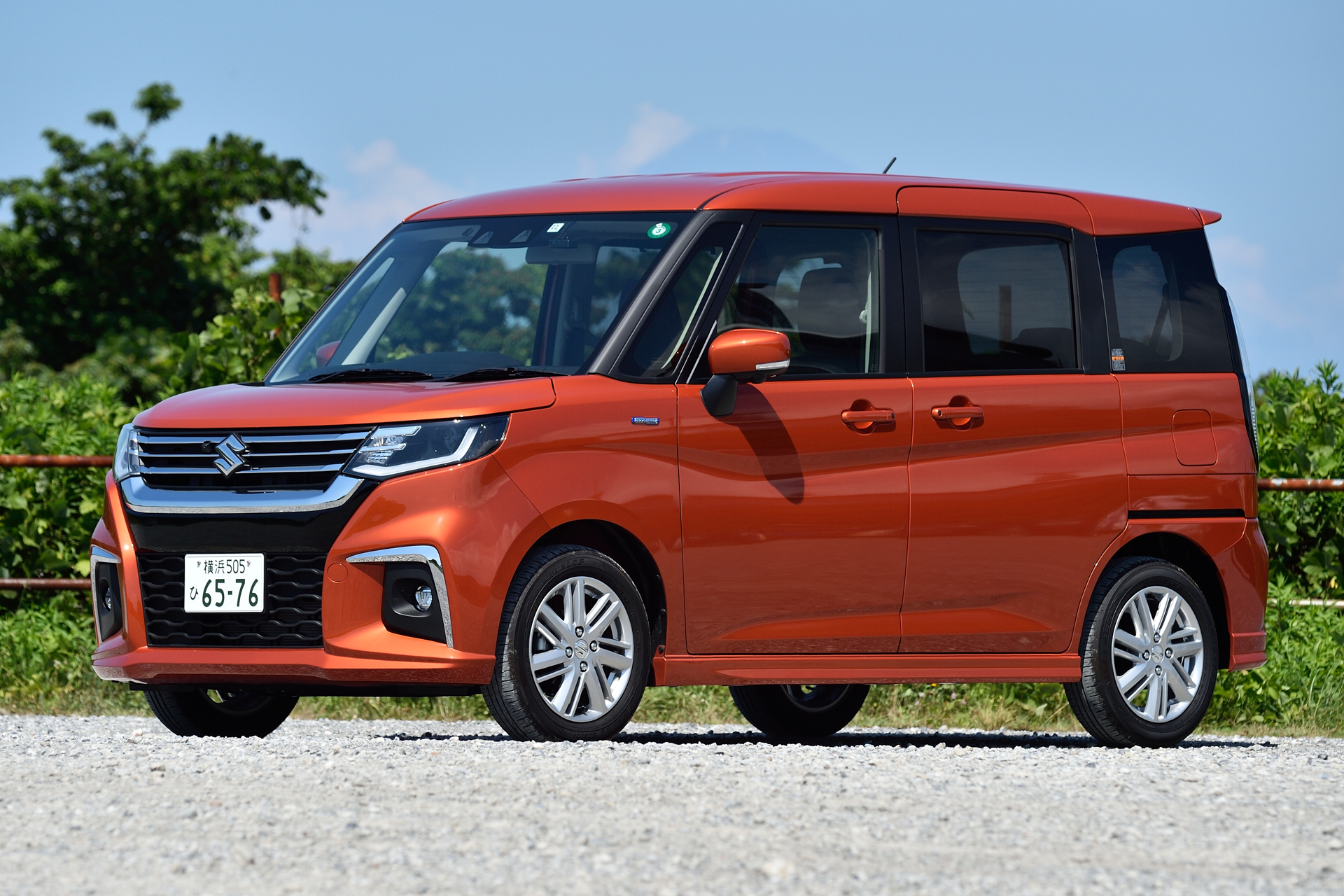 スズキ「ソリオ HYBRID MZ」（202万2900円）。ボディカラーは夏の青空に映える「フレイムオレンジパールメタリック」。ボディサイズは3790×1645×1745mm（全長×全幅×全高）。ホイールベースは2480mmで、最小回転半径は4.8m