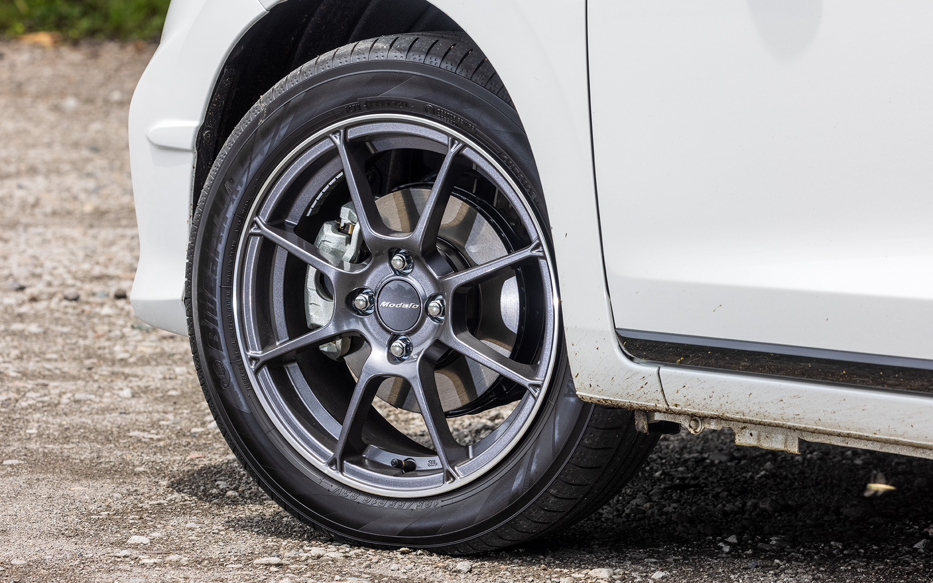 「フィット Modulo X」（286万6600円）。ボディカラーは「プラチナホワイト・パール＆ブラック」。ボディサイズは4000×1695×1540mm（全長×全幅×全高）、ホイールベースは2530mm。専用16インチアルミホイールに組み合わせるのは、185/55R16サイズの横浜ゴム「BluEarth-A」。ベースとなる「e：HEV リュクス」に対し、“実効空力”エアロパーツを数多く装着している