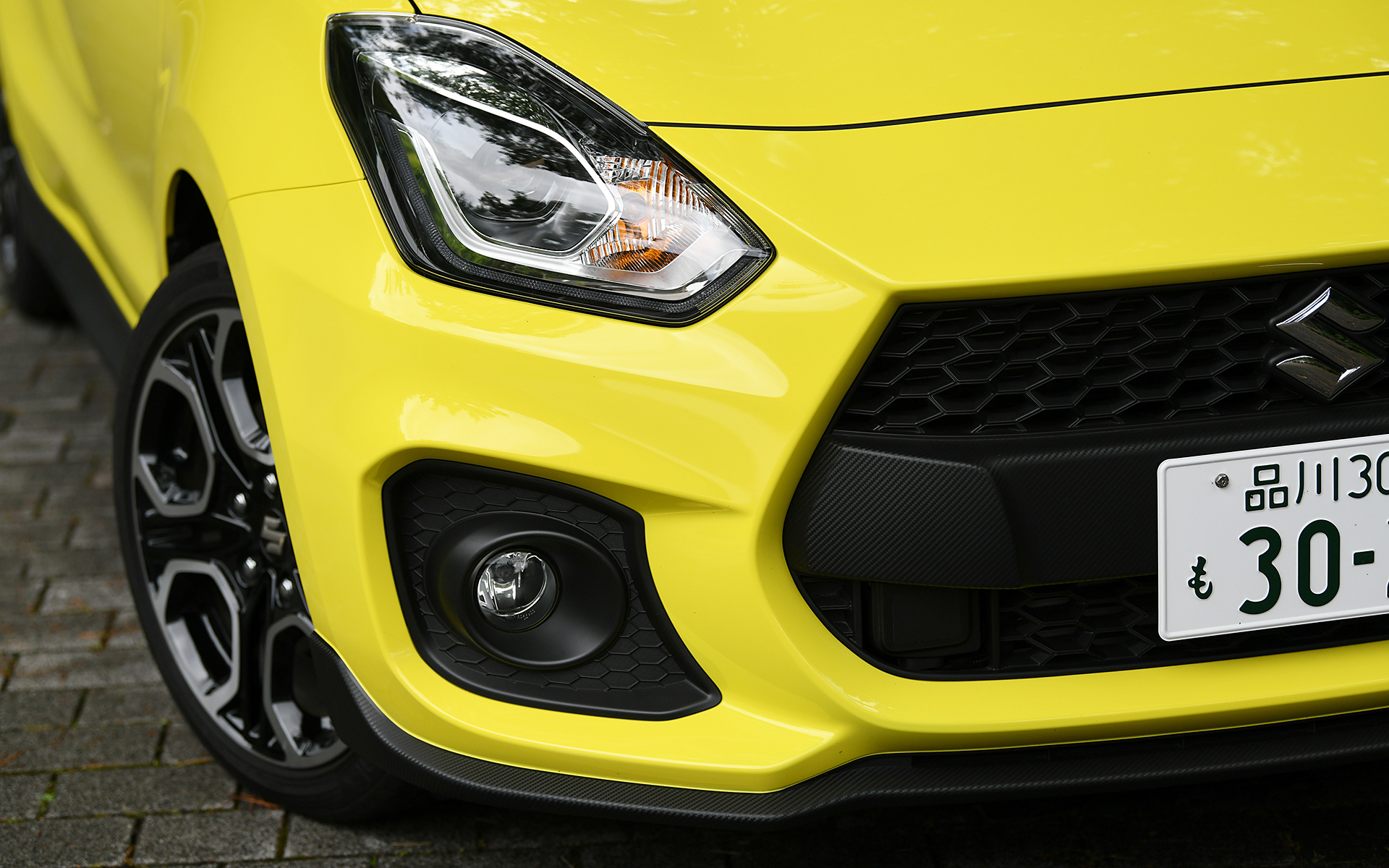 スイフトよりも前方へせり出したノーズで躍動感を演出し、フロントグリルや各部スポイラーなどをカーボン調のシボ仕上げとしてスポーティな印象を与えた。切削加工＆ブラック塗装の17インチアルミホイールには195/45R17サイズのコンチネンタル「ContiSportContact 5」を装着する