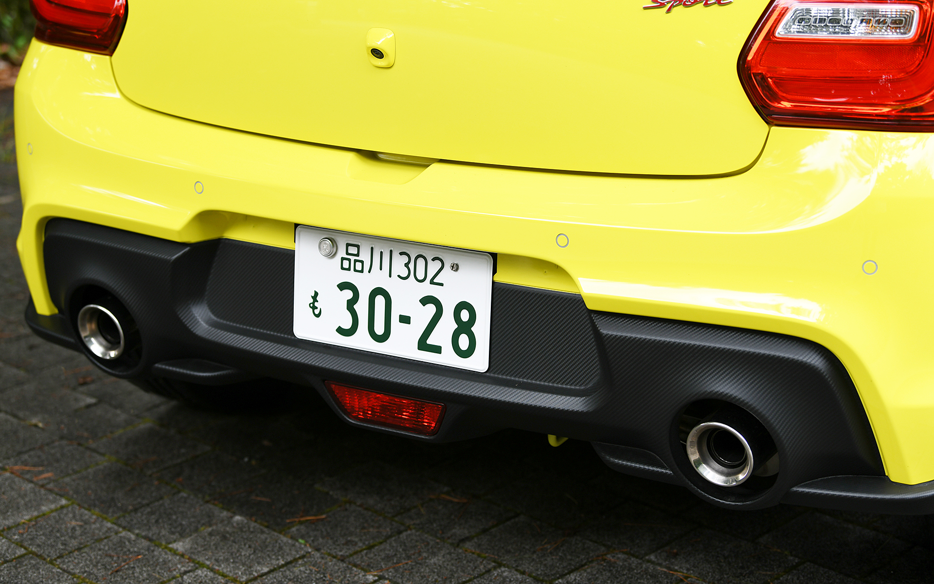 スイフトよりも前方へせり出したノーズで躍動感を演出し、フロントグリルや各部スポイラーなどをカーボン調のシボ仕上げとしてスポーティな印象を与えた。切削加工＆ブラック塗装の17インチアルミホイールには195/45R17サイズのコンチネンタル「ContiSportContact 5」を装着する