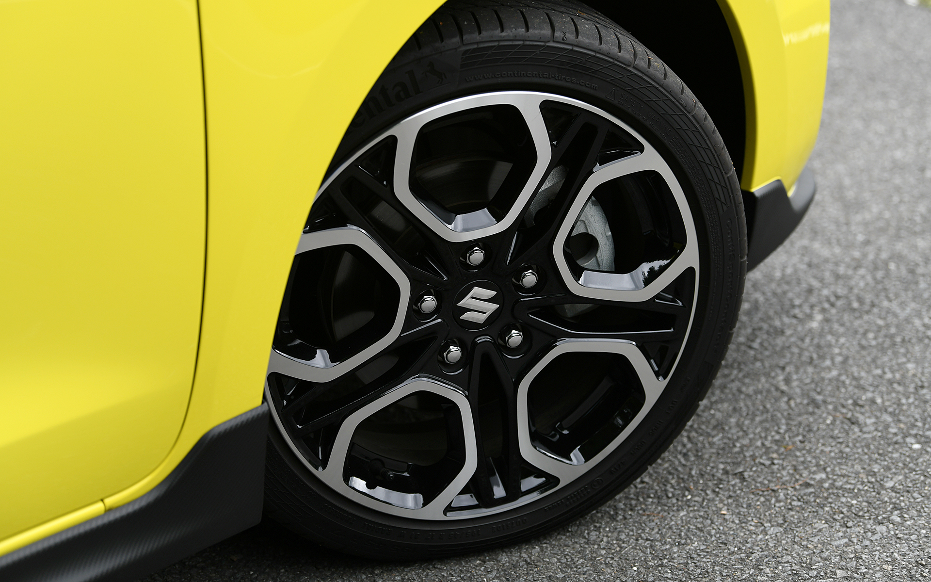 スイフトよりも前方へせり出したノーズで躍動感を演出し、フロントグリルや各部スポイラーなどをカーボン調のシボ仕上げとしてスポーティな印象を与えた。切削加工＆ブラック塗装の17インチアルミホイールには195/45R17サイズのコンチネンタル「ContiSportContact 5」を装着する