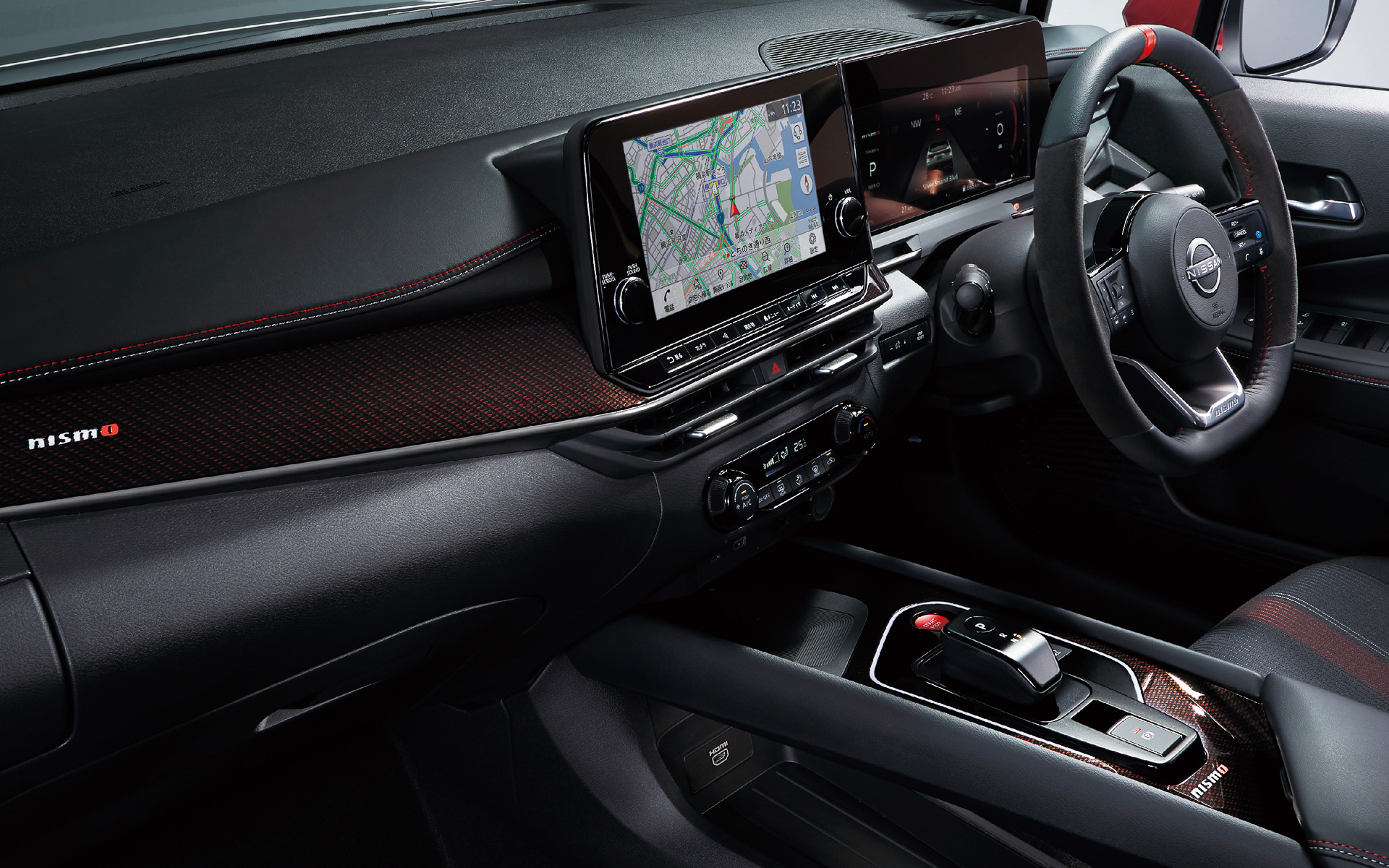 インテリアではダークトーン＆レッドアクセントの色調を特徴とし、専用ファブリックと合皮のコンビネーションを採用したシート（写真はオプションのレカロシート）、NISMO専用の本革・アルカンターラ巻きステアリングなどを採用。NISMOロゴと赤いパワーメーターを用いた専用カラーの12.3インチアドバンスドドライブアシストディスプレイも装備