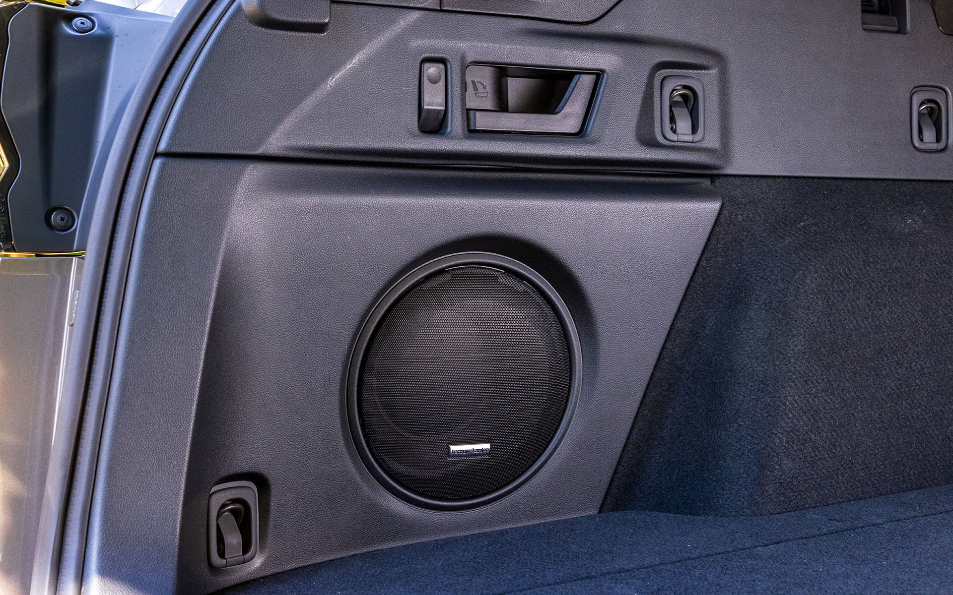 左サイドにはハーマンカードンサウンドシステムのウーファー。上部のハンドルでリアシートの背もたれをワンタッチで倒すことが可能