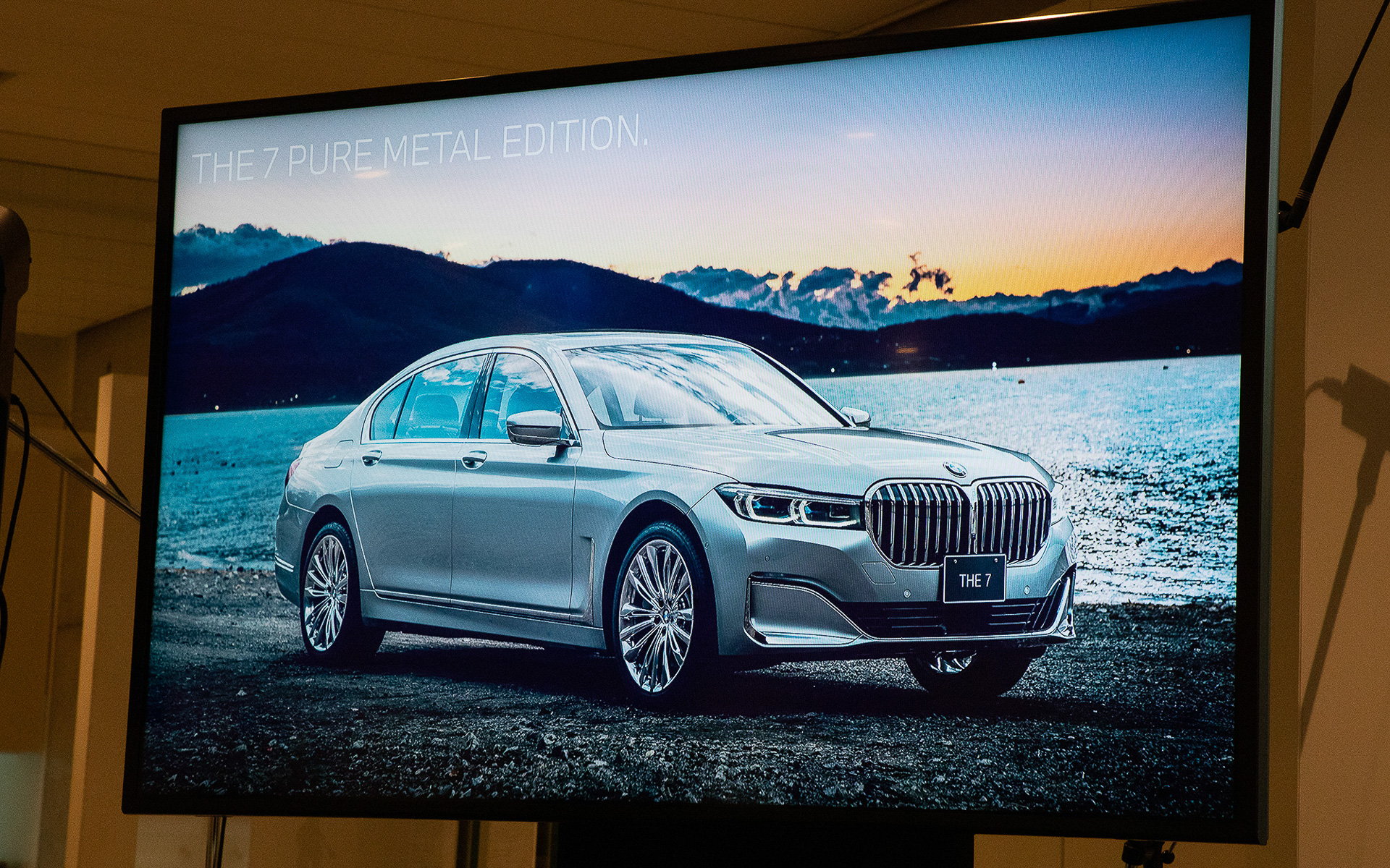 「750Li xDrive PURE METAL EDITION」の解説。ダッシュボードに追加された銀板には「冬のしだれ桜」が描かれる。加えてリアシートにセットされる銀のカップには開花している「桜」を描くことで車内に季節のうつろいを表現したという