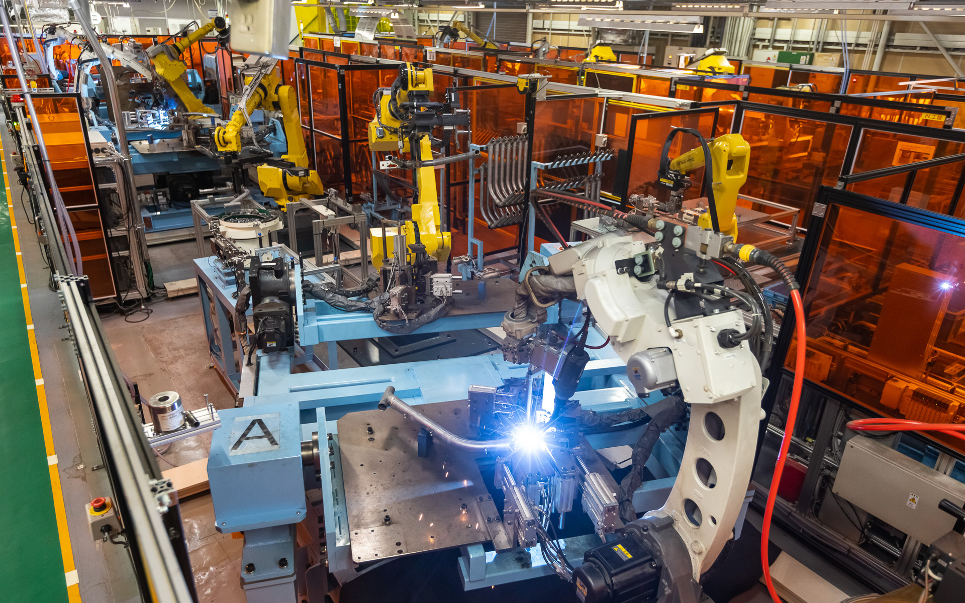 自動溶接設備では溶接作業に加えて溶接後のフレーム搬出などもロボットが自動で行なう