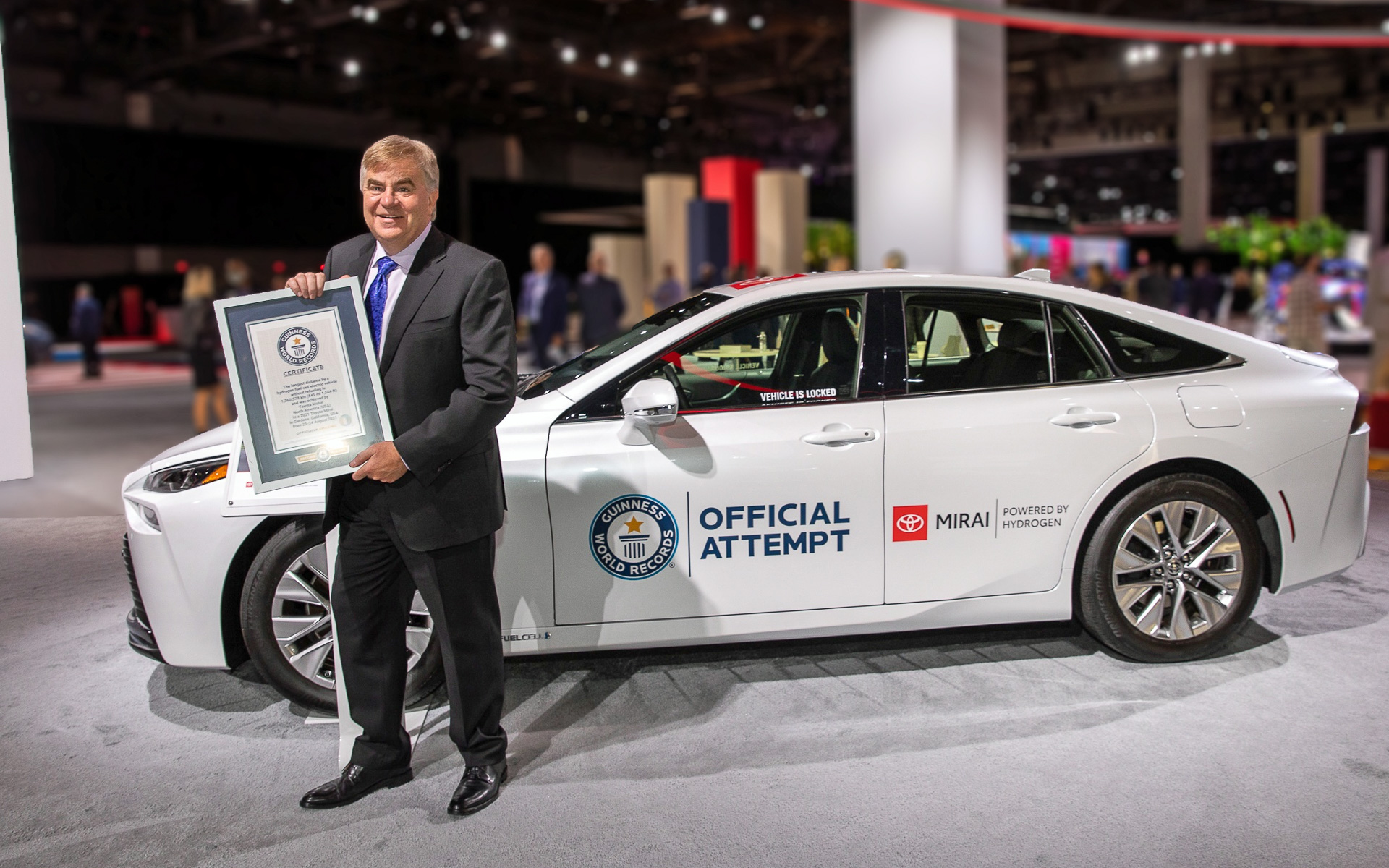 記録達成に使用されたミライとギネス世界記録の認定証を手にするトヨタモーターノースアメリカのエグゼクティブ・バイス・プレジデントであるボブ・カーター氏