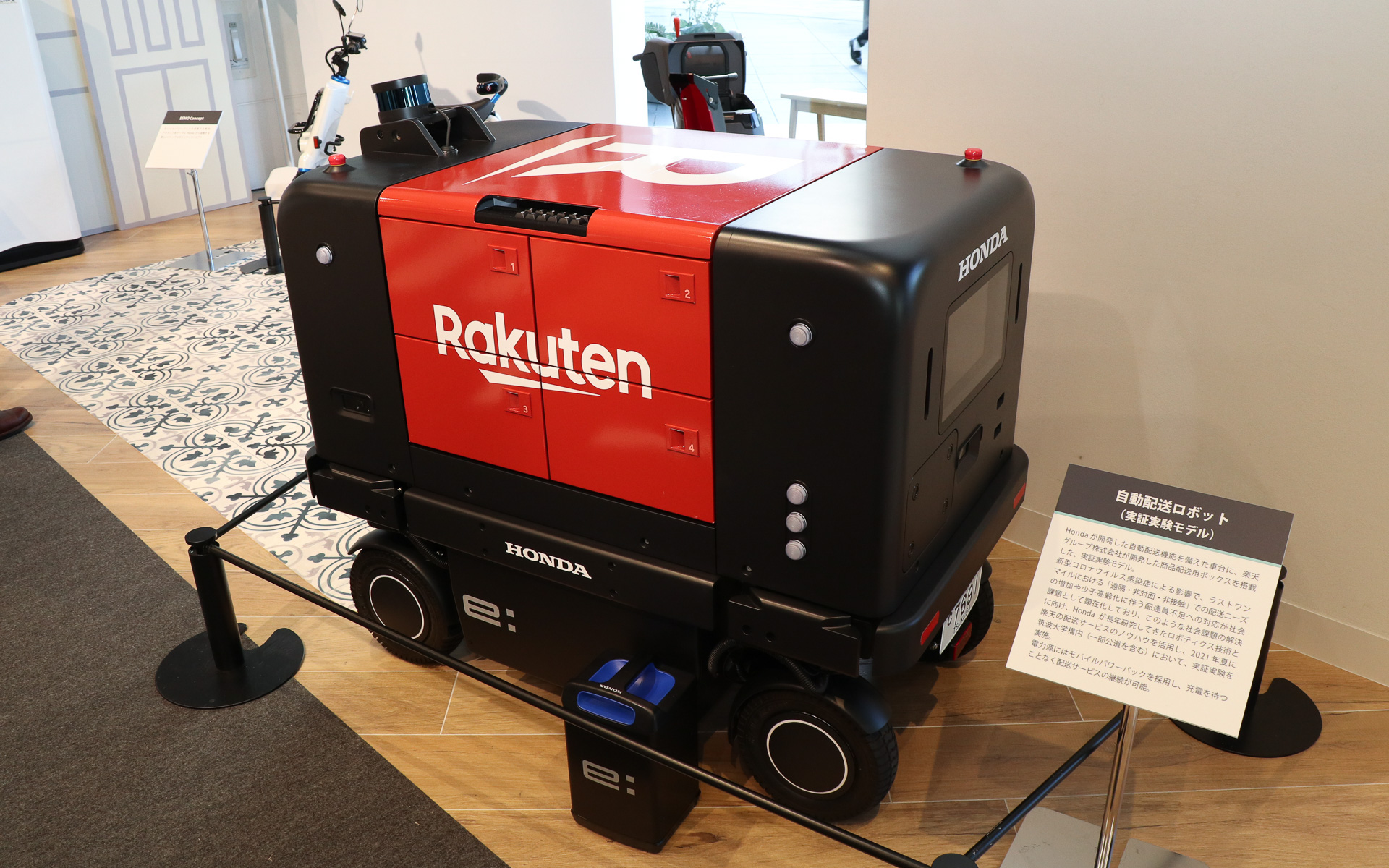 ホンダと楽天が共同で行なっている走行実証実験で利用されている自動配送ロボット。黒い部分はホンダが開発したプラットフォーム型ロボティクスデバイス、赤い部分は楽天の商品配送ボックス