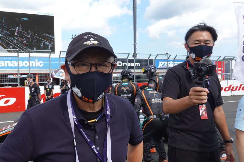 2020年スーパーフォーミュラ開幕戦を訪れたトヨタ自動車株式会社 代表取締役 豊田章男氏（左）。にゃんこ大戦争マスク、ポロシャツ、短パンというカーガイルックでグリッドを楽しんでいた